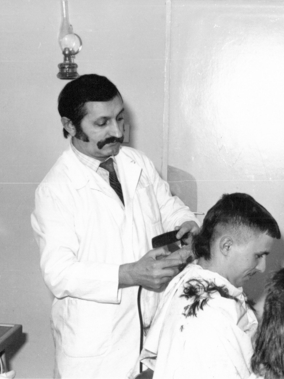 Dziadek Jerzy przy pracy w rodzinnym zakładzie fryzjerskim, lata 70.