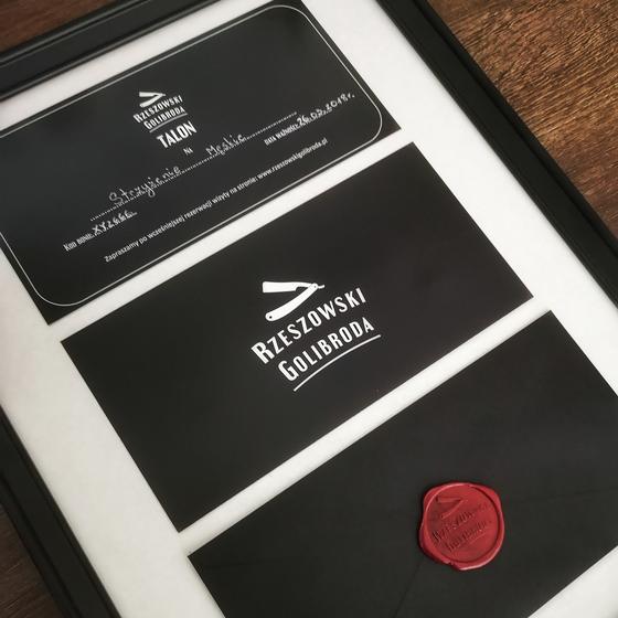 Talon podarunkowy Rzeszowskiego Golibrody: czarny talon z białym logo, czarna koperta i czerwona lakowa pieczęć